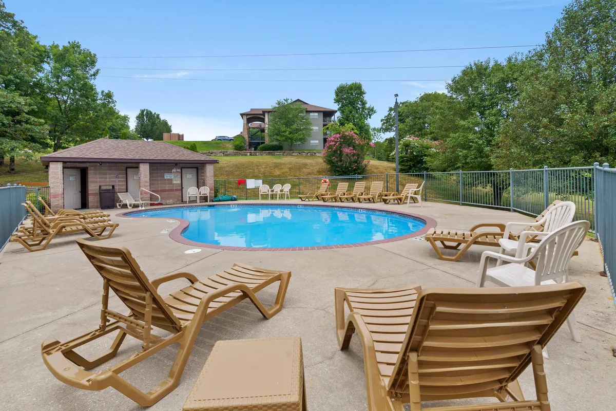 An inviting resort-style swimming pool area surrounded by lush greenery, complete with lounge chairs and a poolside gazebo, creating a welcoming spot for both relaxation and social gatherings with friends.